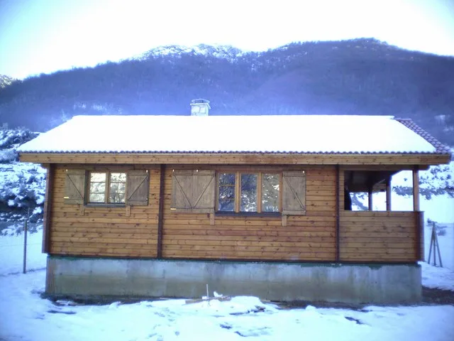 Casa prefabricada de madera T-14 en L con porche de Maderhouse