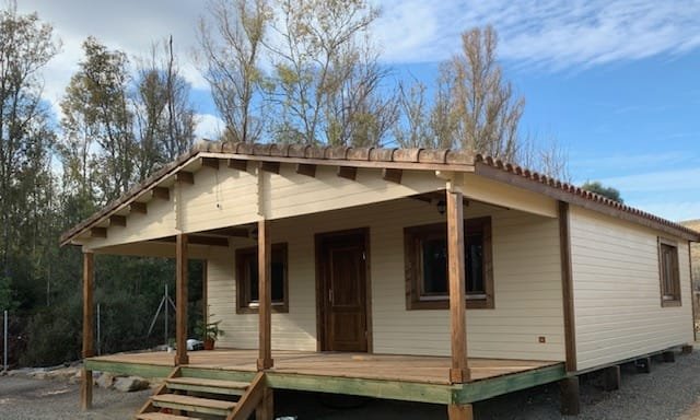 Casa prefabricada de madera modelo Bolonia Plus con porche de Casas de Madera Yustas