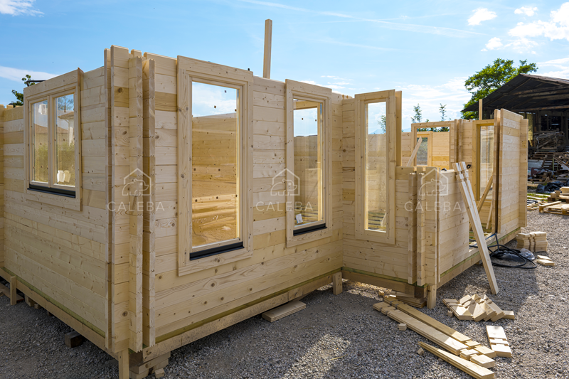 Vivienda Blockhaus en pleno montaje, con los muros de madera y las ventanas ya colocados.