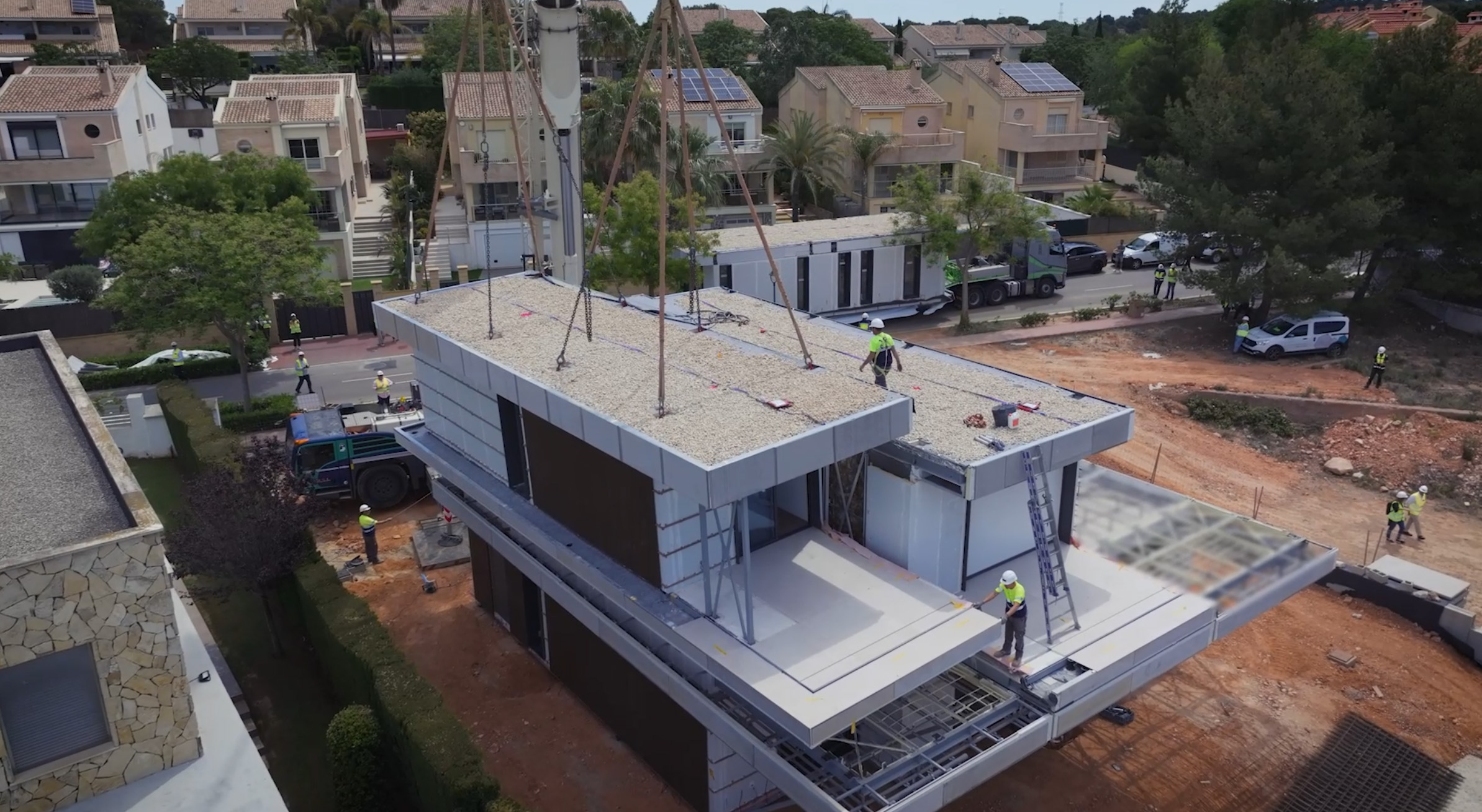 Grúa depositando un módulo sobre la planta superior de una vivienda EMOHA de dos alturas (Bétera, Valencia).