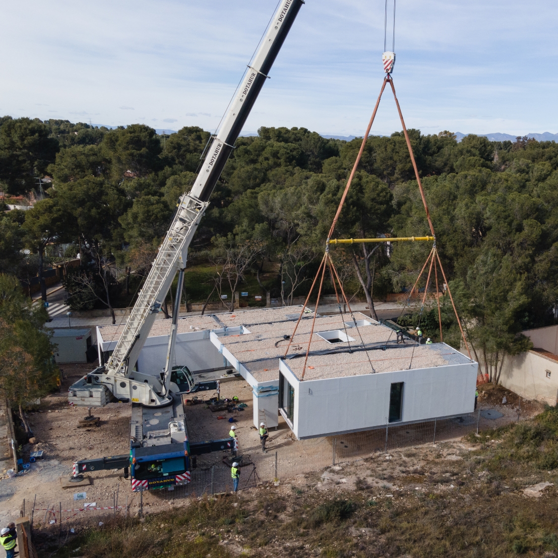 Grúa móvil montando in situ los módulos de una casa EMOHA de una sola planta.