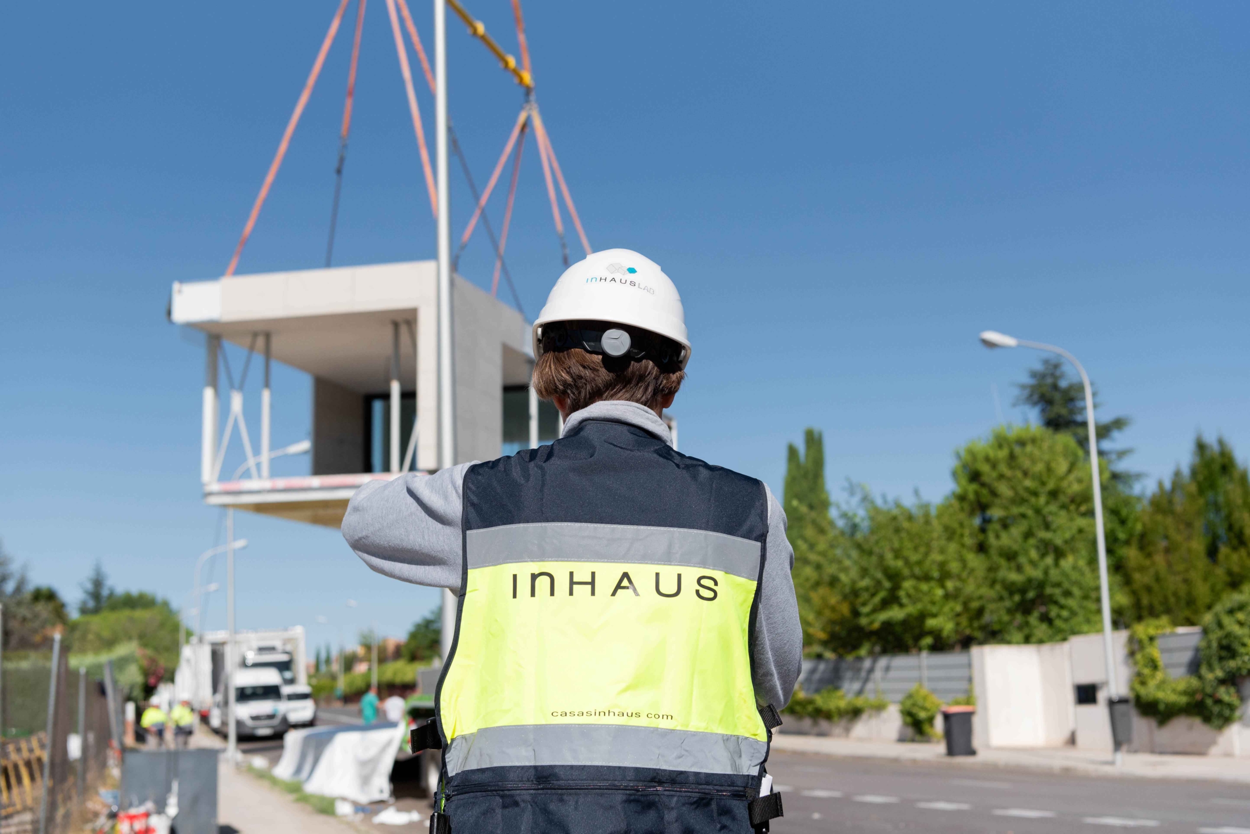 Operario de inHAUS Lab supervisando el izado de un módulo con voladizo hacia su posición final.